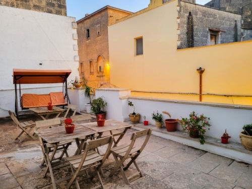 a patio with a wooden table and chairs on a building at Mercanti in Manduria