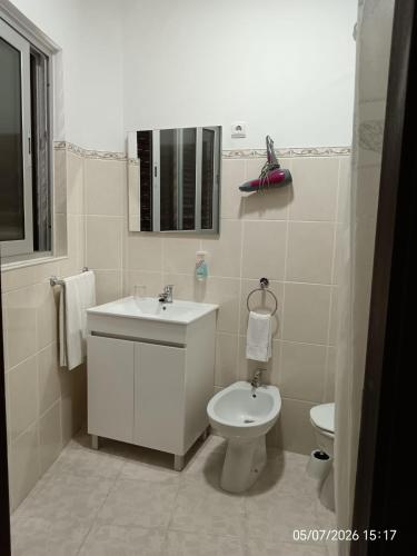 a white bathroom with a sink and a toilet at Casa Feijao - Alojamento Local in Geres
