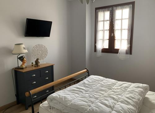 a bedroom with a bed and a dresser and a television at Chez Martine Et Michel in Pléneuf-Val-André