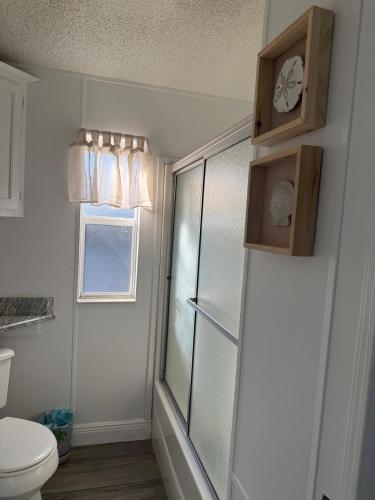 a bathroom with a toilet and a clock on the wall at Beach Bum Bungalow in Jensen Beach