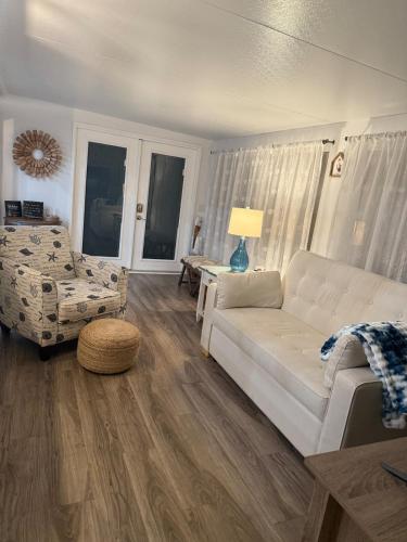 a living room with a white couch and a chair at Beach Bum Bungalow in Jensen Beach
