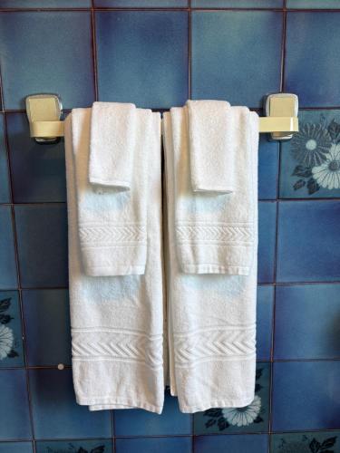 three towels hanging on a towel rack in a bathroom at Moledo Seaview in Moledo