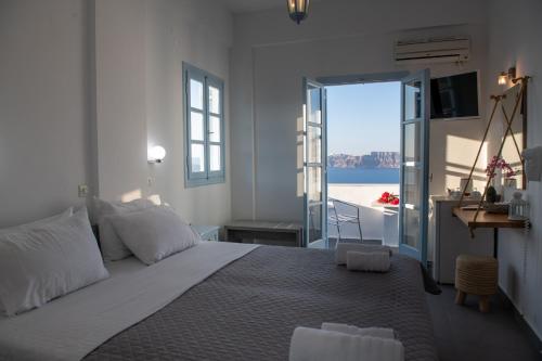 a bedroom with a bed with a view of the ocean at Blu Rooms Santorini in Akrotiri