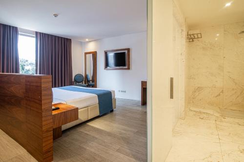 a hotel room with a bed and a walk in shower at Afrin Prestige Hotel in Maputo
