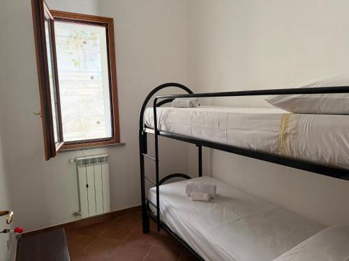 a room with two bunk beds and a window at Marinella Retreat - Sole in Zambrone