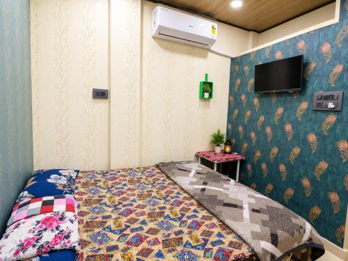 a bedroom with a bed and a tv on a wall at hotel shree guru pandey in Indore