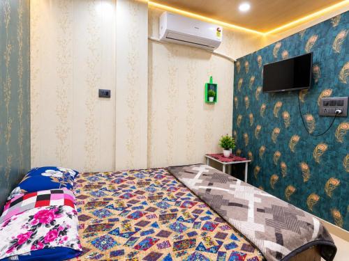 a bedroom with a bed and a tv on a wall at hotel shree guru pandey in Indore