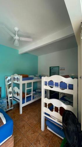 a room with three bunk beds and a ceiling at Pousada Casa do Rio - 8 min do Centro Hístorico in Paraty