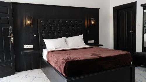 a bedroom with a large bed with a black headboard at Adam's Palm Resort in Talaimannar