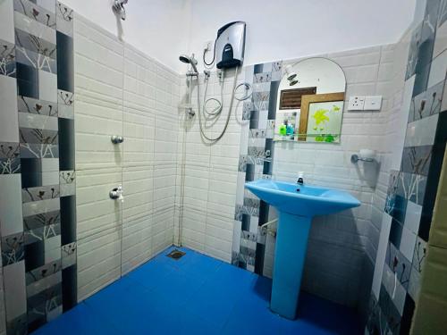a bathroom with a blue sink and a shower at Gangadiya Lodge Sigiriya in Sigiriya