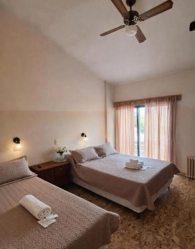 a bedroom with two beds and a ceiling fan at KIN Hotel in Villa Carlos Paz