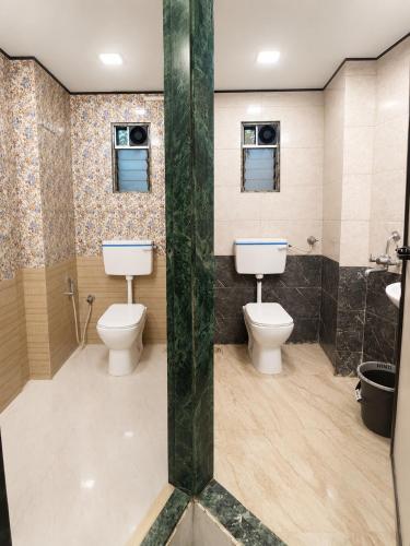 a bathroom with two toilets and a sink at Andheri-69-Dormitory in Mumbai