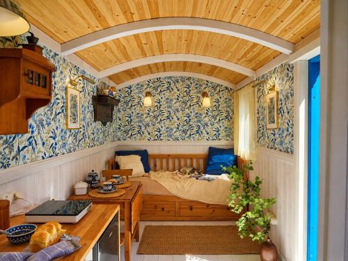 a bedroom with a bed in a room with blue wallpaper at Tiny House Zajączki nad Narwią in Zajączki