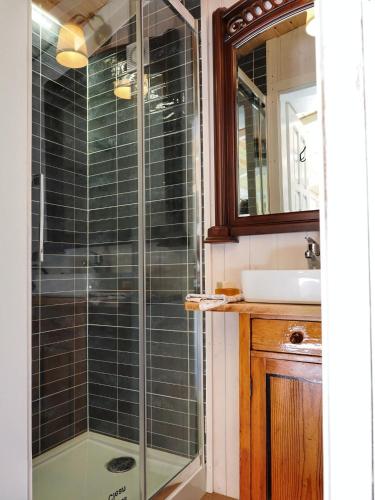 a glass shower in a bathroom with a sink at Tiny House Zajączki nad Narwią in Zajączki