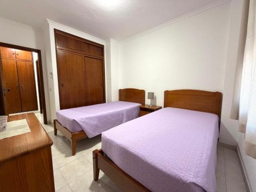 a bedroom with two beds and a dresser at Edificio Nau B in Armação de Pêra