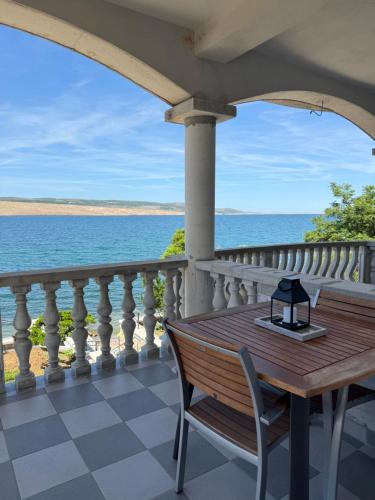 a table and chairs on a balcony overlooking the ocean at Villa Punta in Rovanjska