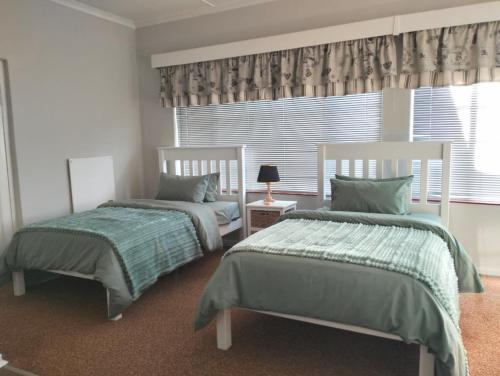 a bedroom with two beds and a window at Kapokbos in Sutherland