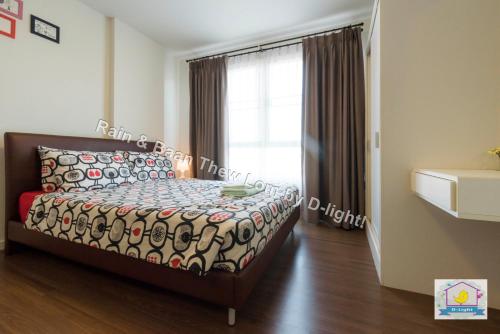 a bedroom with a bed and a window at Baan Thew Lom by D-light in Cha Am