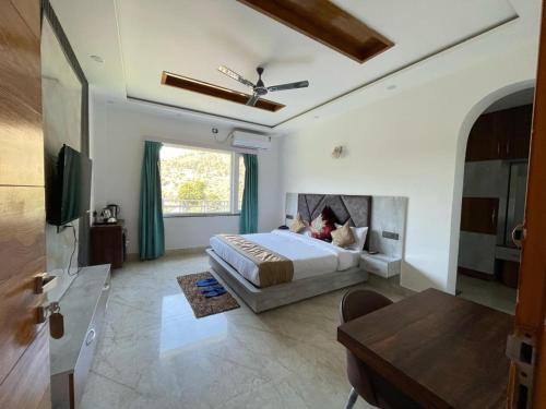 a large bedroom with a bed and a table at Jayati Palace Hotel in Rudraprayāg