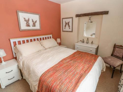 a bedroom with a bed and a chair and a mirror at Kernot Cottage in Richmond