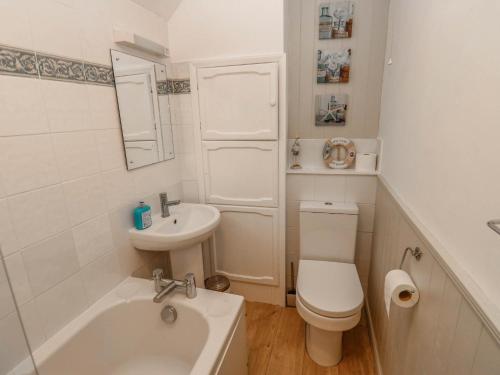a white bathroom with a toilet and a sink at Kernot Cottage in Richmond