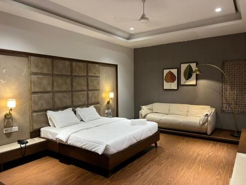 a bedroom with a large bed and a couch at DK Club & Resort in Bārdoli