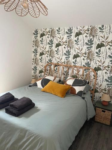 a bedroom with a bed with a patterned wall at L'étoile des pins in Longeville-sur-Mer