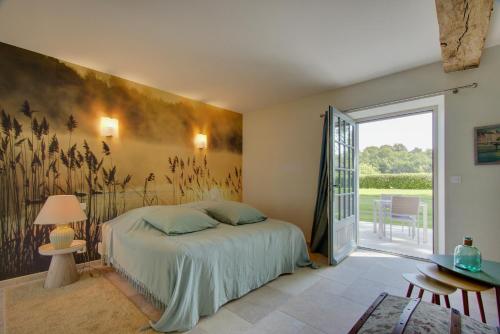 a bedroom with a bed and a large window at Cloffy et son Domaine in Nouans-les-Fontaines