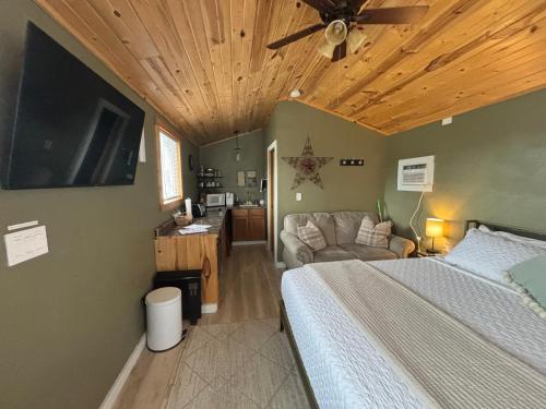 a bedroom with a bed and a flat screen tv at Eagle’s Landing Lodge in Custer