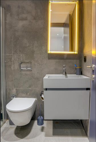 a bathroom with a toilet and a sink and a mirror at FOR LARGE FAMILIES, DUPLEX Vılla-304 in Çeşme