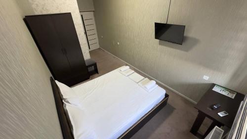 a hospital room with a bed and a flat screen tv at Sohil Hotel in Stantsiya Kyzyl-Tukumachi