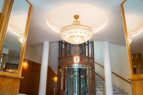 Ein Kronleuchter hängt von der Decke eines Gebäudes. in der Unterkunft Hotel Park Central in Sliven