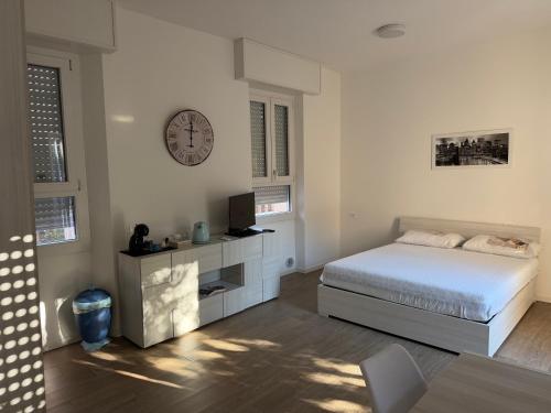 a bedroom with a bed and a clock on the wall at Artexia residence DIAMANTE A1 in Valenza