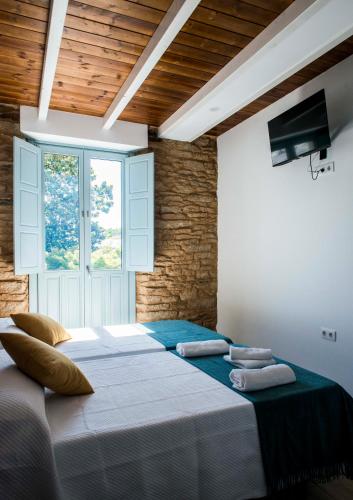 a large bed in a room with a window at A Calexa Sarria nº4 in Sarria