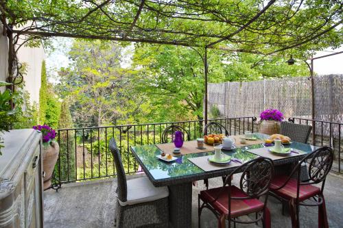 une table et des chaises sur un balcon avec une table et des chaises dans l'établissement La Pergola, à Châteauneuf-du-Pape
