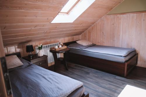 two twin beds in a room with a skylight at Pokoje Gościnne Sandomingo in Sandomierz