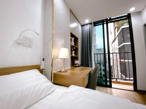 a bedroom with a bed and a desk with a window at Caelistay in Hanoi
