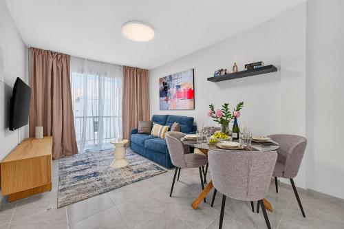a living room with a table and a blue couch at Coast Suites in Alcalá