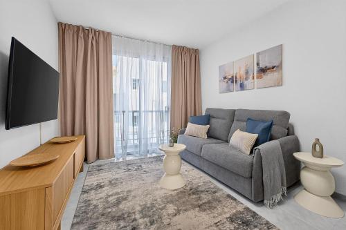 a living room with a couch and a tv at Coast Suites in Alcalá