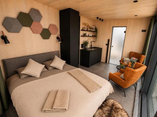 a bedroom with a large bed and a chair at Camp Boutique in Gaulverjabær