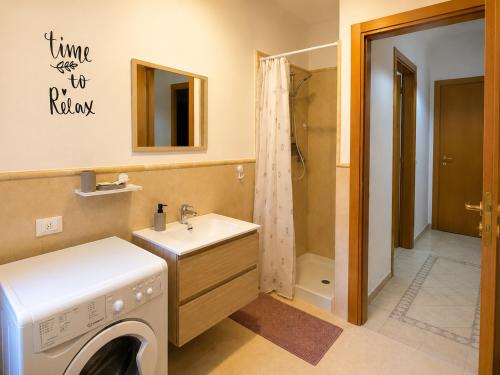 a bathroom with a washing machine and a sink at Casa Iris in Montepulciano
