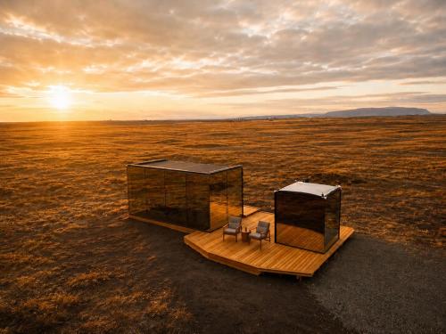 a small house in the middle of a field at Camp Boutique in Gaulverjabær