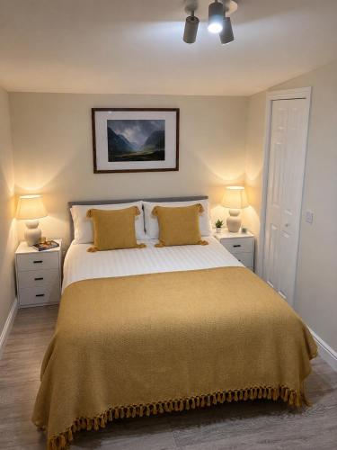 a bedroom with a large bed with two lamps at Minch View Cabin 1 in Earlish