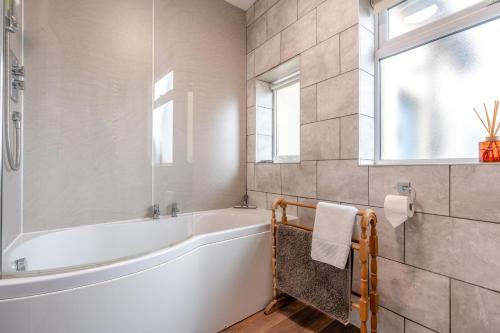 a white bathroom with a tub and a window at 5 Bed in Beadnell oc-24955 in Beadnell