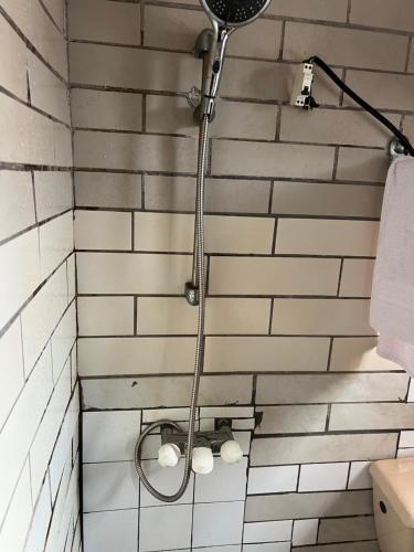 a shower in a bathroom with white tiles at Studio meublé akwa in Douala