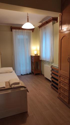 a bedroom with a bed and a dresser and two windows at Vasiliki Bay in Vasiliki