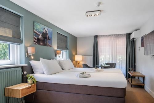 a bedroom with a large white bed in a room at Hotel 't Paviljoen in Rhenen