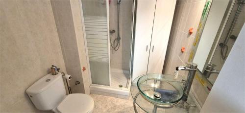a bathroom with a toilet and a glass sink at Estudio playa in Bellreguart