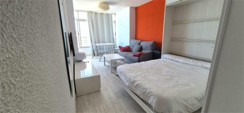 a small bedroom with a bed and a couch at Estudio playa in Bellreguart