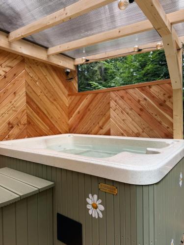 a jacuzzi tub in a building with a wooden ceiling at Tiny nad potokiem - Leśny in Sidzina